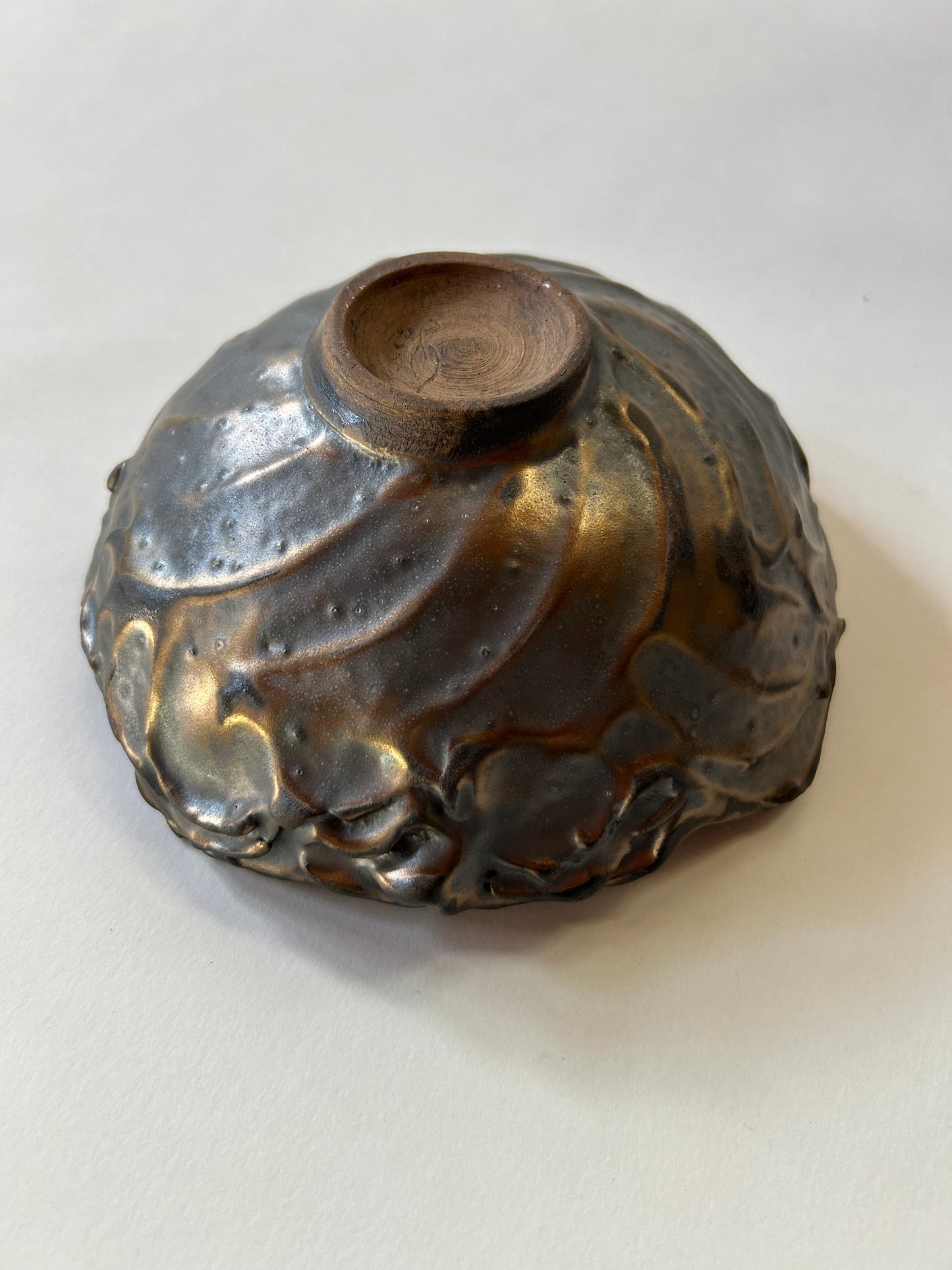 view of the bottom of bowlshowing the spiral and it's morphing into sculpted forms resembling waves or lava